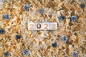 wooden numbers 2022 cubes symbolizng Christmas or new year celebration. pine cones and shavings