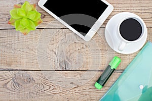 Wooden office table with computer, pen and a cup of coffee, lot of things. Top view with copy space