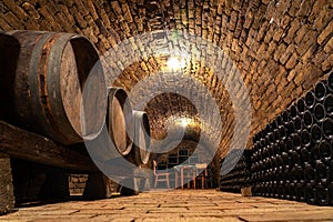 Wooden old barrels in the rustic wine cellar with brick walls in hajos hungary