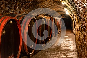 Wooden old barrels in the rustic wine cellar with brick walls in villany hungary