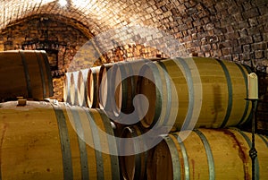 Wooden old barrels in the rustic wine cellar with brick walls in villany hungary