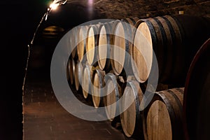 Wooden old barrels in the rustic wine cellar with brick walls in villany hungary