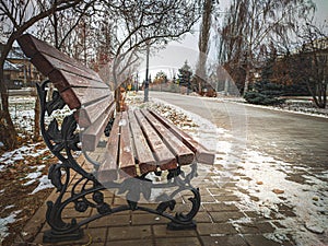 Wooden old bench in a winter alley