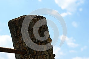 Wooden old brown crossroad sign on a blue sky with clouds