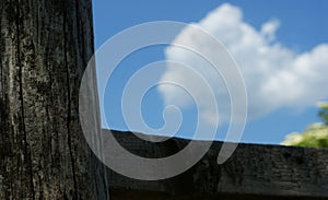 Wooden old brown crossroad sign on a blue sky with clouds