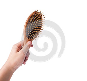 Wooden old comb in hand on blackground