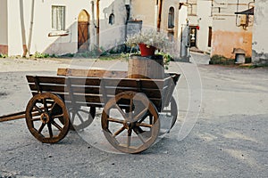 Wooden old-fashioned cart, decorative retro wagon in the yard, vintage stand for flowers, garden decor
