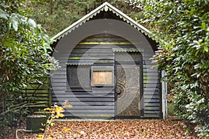 Wooden, old house in the woods in autumn scenery, shelter in the woods.