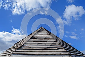 Wooden old rusty roof pattern with blue cloudy sky