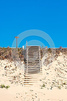 Wooden old stairs going up built on sand dunes