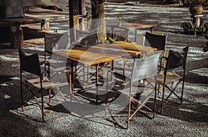 Wooden old table and Empty folding camping chairs in front of the house