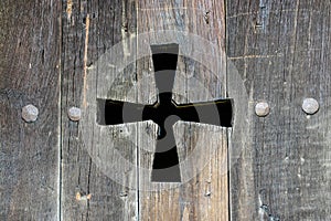 Wooden old window shutters with carved catholic cross close-up