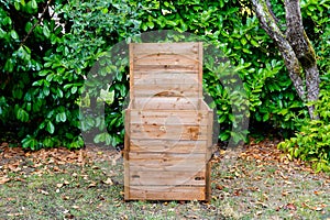 Wooden open in home garden compost bin with organic material