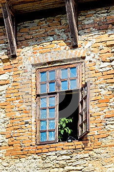 The wooden open window of the old house, the stone wall without