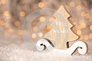 Wooden ornament cutout in the shape of a pine tree with copy space - translation text Feliz Navidad - merry christmas