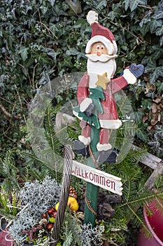 Wooden outdoor Santa Claus sign with the German text `Willkommen`