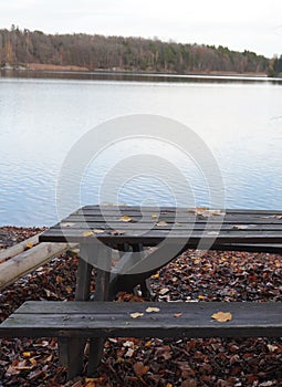 Wooden outdoors furniture at lake during autumn