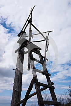 Wooden outpost made of wood. Simple lookout tower in forest