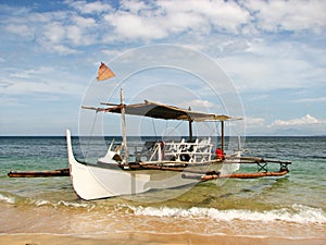 Wooden Outrigger Boat on a Beach Shore