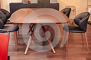 Wooden oval table with black leather chairs