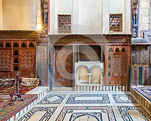 Wooden painted floral patterns, arched niche, wooden door, decorated cupboard, and marble floor photo