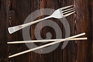 Wooden pairs of chopsticks vs fork. Abstract conceptual image