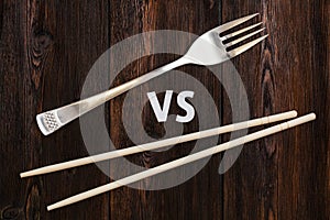 Wooden pairs of chopsticks vs fork. Abstract conceptual image