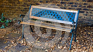 Wooden park bench in dry leaves