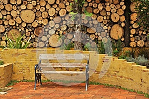 Wooden park bench in a log wall