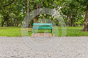 Wooden park bench under trees .