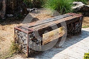 Wooden park benches are made from logs and stones