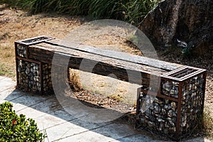 Wooden park benches are made from logs and stones