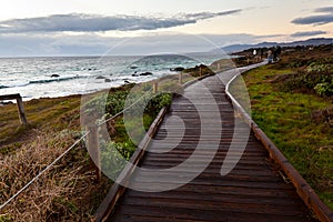 Wooden path along side the sea at sunset
