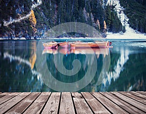 Wooden path at alpine mountain lake at autumn season.