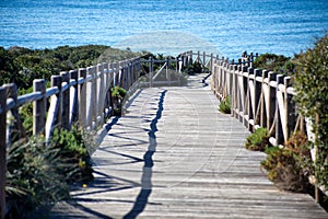 Wooden path on sand dunes close to the sea photo