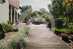 Wooden path to terrace in the garden with trendy garden furniture photo