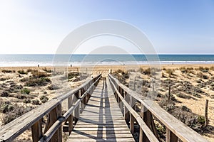 Wooden pathway over dunes and pines at beach in Punta Umbria, Huelva. Los Enebrales beach