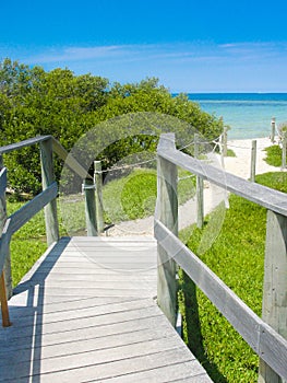 Wooden pathway in white sand beach photo