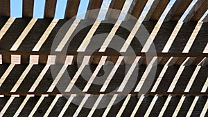 A wooden patio cover showing the sunshine and shadows creating a neat pattern on the boards.