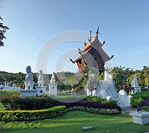 Wooden Pavillion and white lion guardian on green lawn