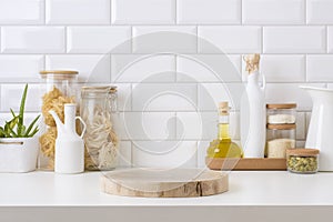 Wooden pedestal on table in kitchen interior with food ingredients