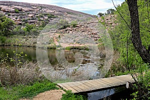 A wooden pedestrain bridge on a hiking trail - Enchanted Rock State Park, Texas