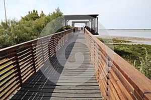 Wooden pedestrian bridge by the sea with rest Ã¡rea for people photo