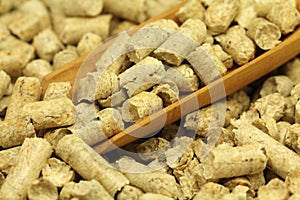 Wooden pellets in dimensional scoop background
