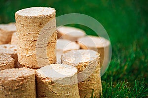 Wooden pellets on green grass background