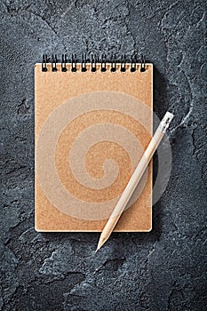 Wooden Pencil On Opened Notepad Black Stone Background