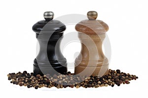 Wooden pepper grinder with bulk dry peppercorns isolated on white