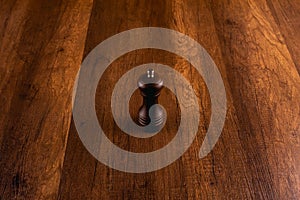 Wooden pepper grinder with pepper on wooden background.