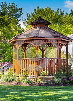 Wooden pergola at the beautiful green garden with flowers