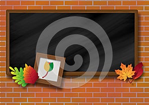 Wooden photo frame with autumn leaves on school blackboard and brick wall background.
